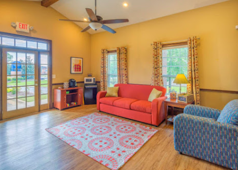 a living room with a red couch and blue chairs
