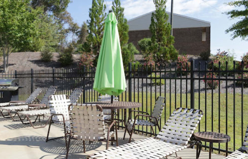 a patio with chairs and umbrella